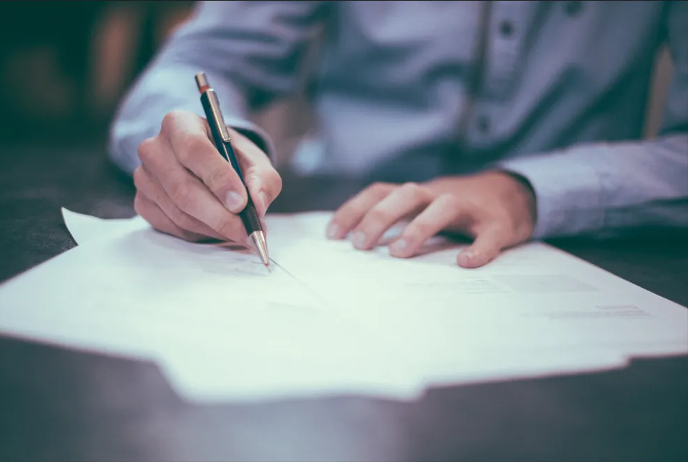 Main d'un conseiller funéraire signant un document important